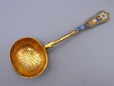 An enamel decorated silver gilt sifter spoon bearing Russian marks. 16.5 cm long.