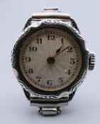 A 1920s silver engraved cased ladies wristwatch, on a stainless steel strap, in working order.