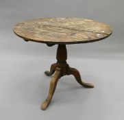 A George III oak tilt top tripod table. 90 cm diameter.