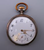 A silver pocket watch. 5 cm diameter.