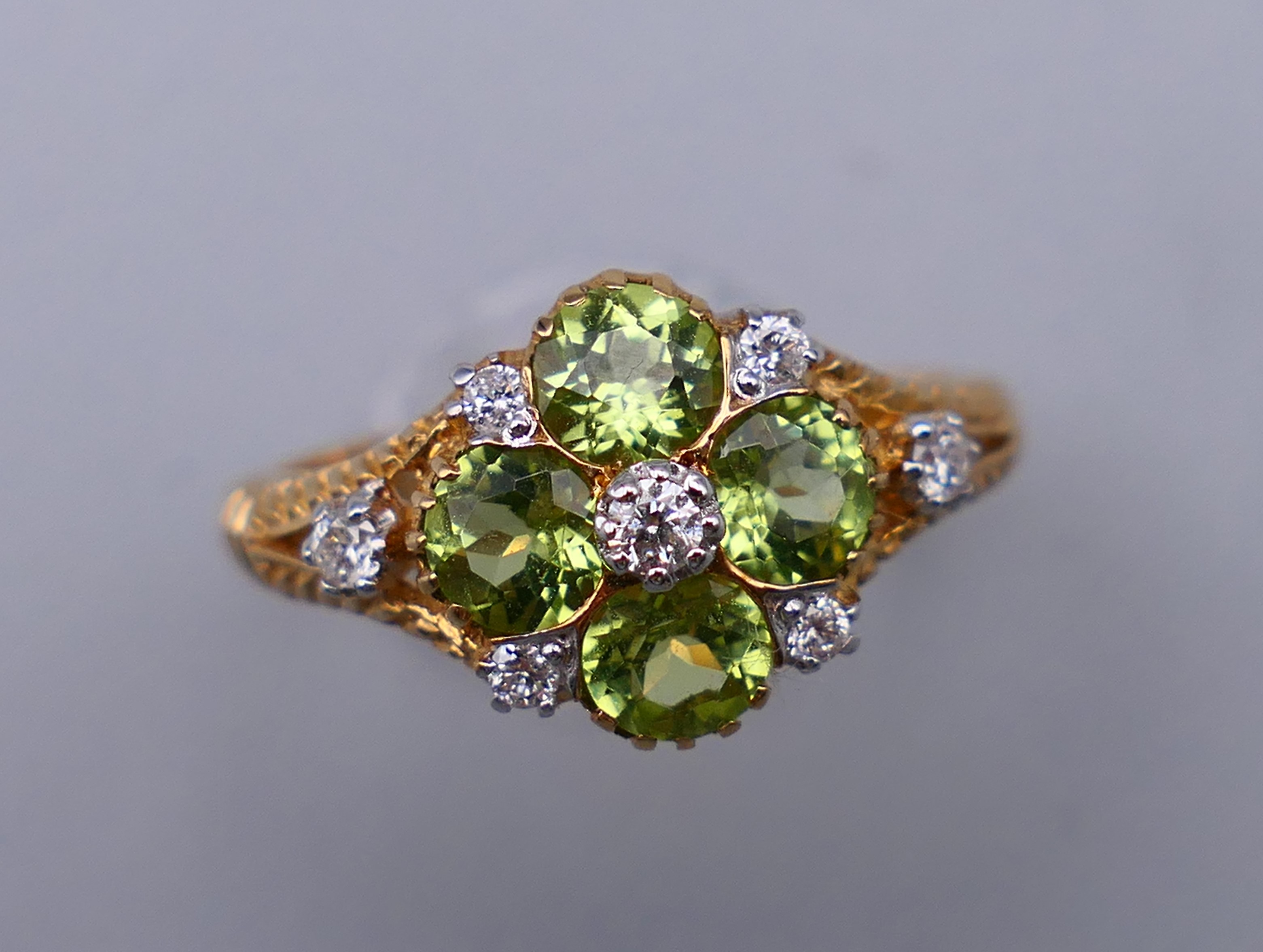 A 9 ct gold Victorian style diamond and peridot ring, engraved design to the sides. Ring size M/N.