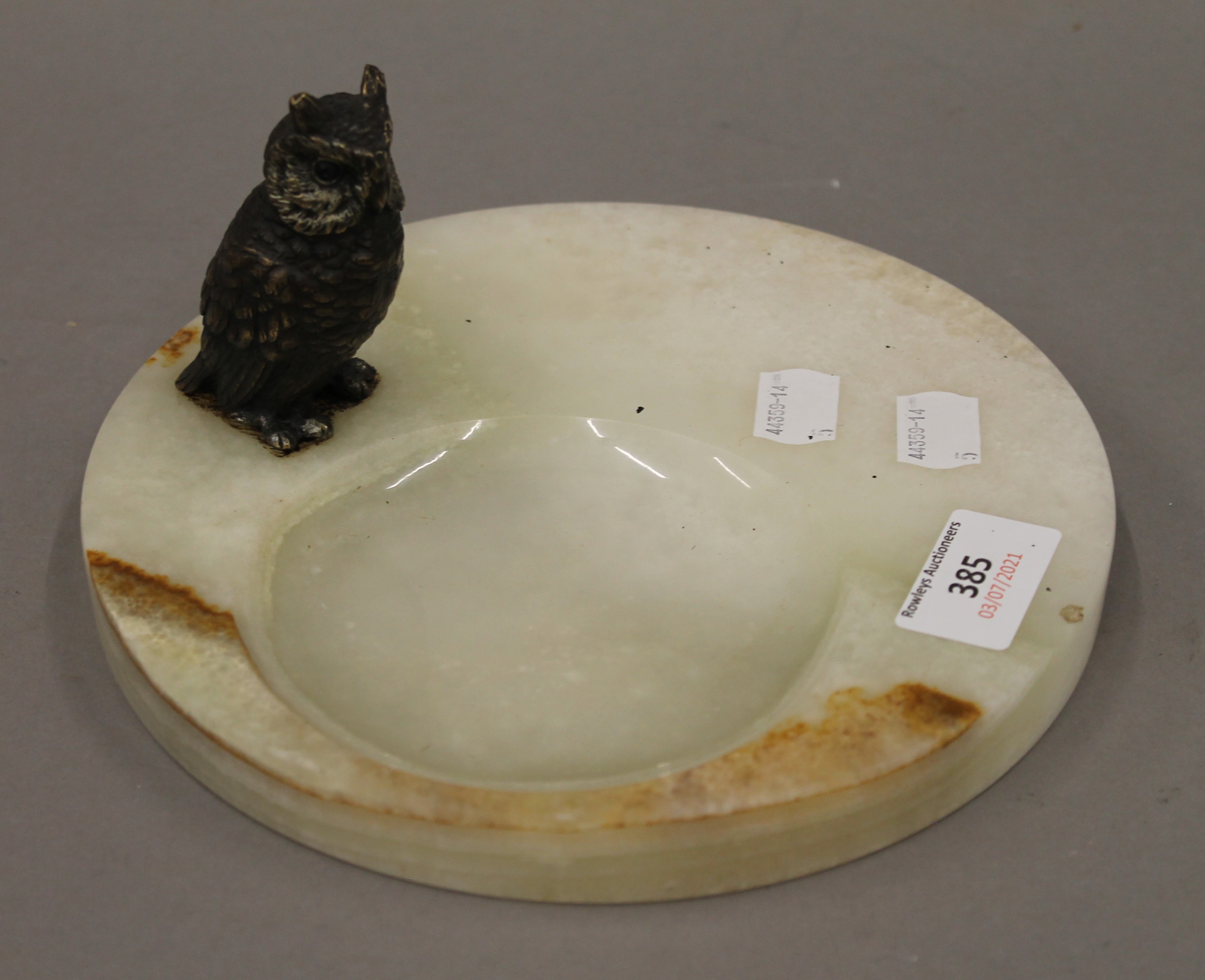 A cold painted bronze model of an owl mounted on an onyx dish. 19.5 cm diameter.