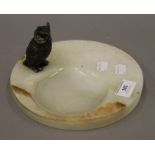 A cold painted bronze model of an owl mounted on an onyx dish. 19.5 cm diameter.
