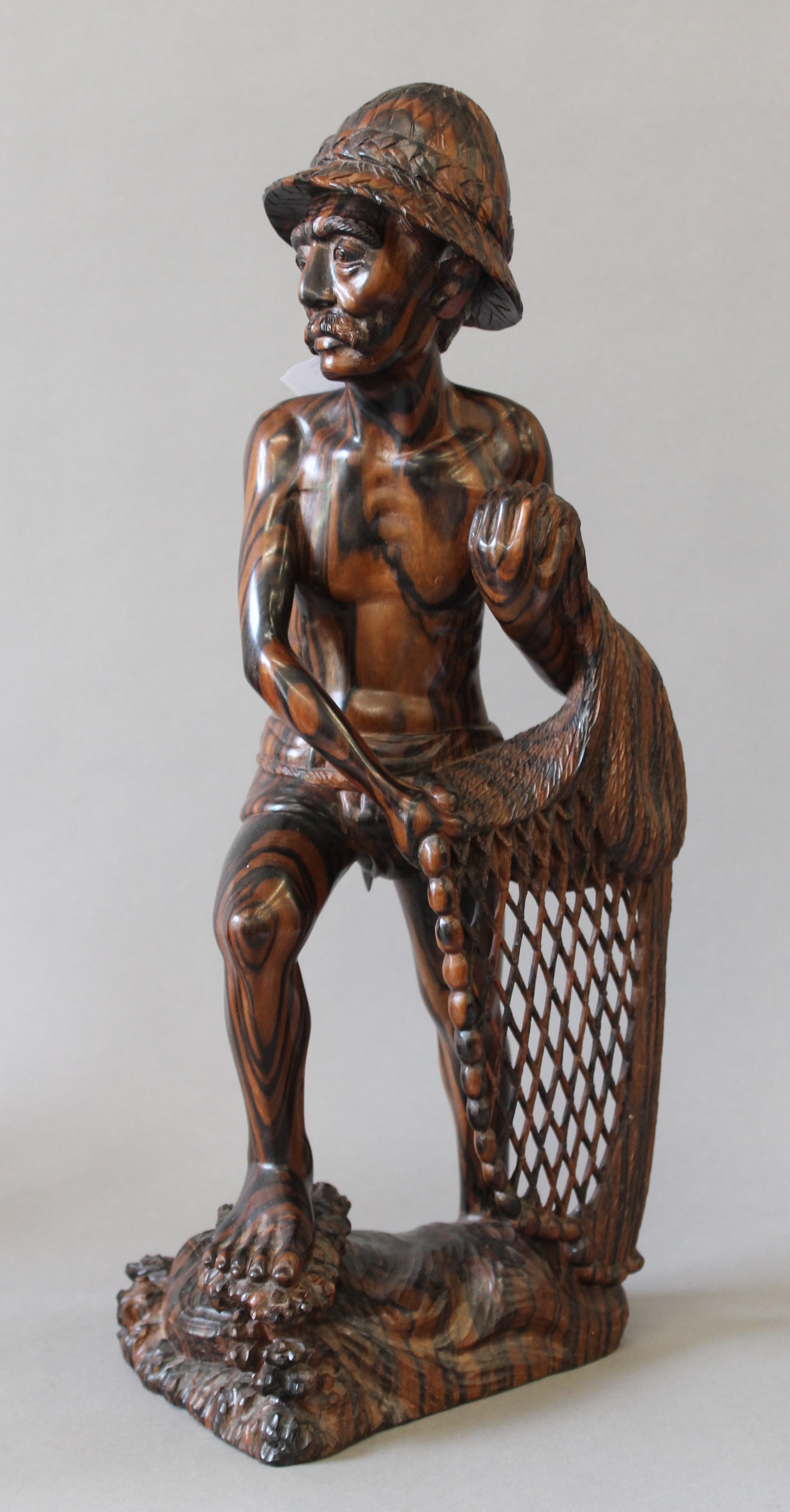 An Eastern carved hardwood fisherman figure. 43 cm high.