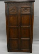 An 18th century style oak two drawer wardrobe. 96 cm wide.