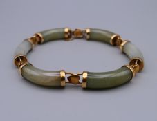 A jade and 14 K gold bracelet. 18 cm long.