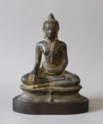 An antique bronze model of Buddha mounted on a wooden base. 21 cm high.