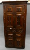 An 18th century oak geometrically moulded standing corner cupboard. 201.5 cm high.