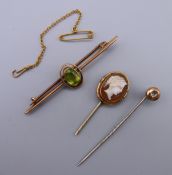 An unmarked gold bar brooch and two stick pins.