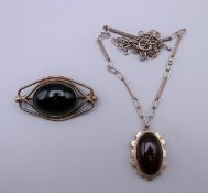 A silver and amber pendant on chain, together with a brooch.