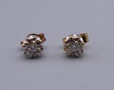 A pair of 9 ct gold diamond solitaire earrings. 5 mm diameter.