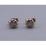 A pair of 9 ct gold diamond solitaire earrings. 5 mm diameter.