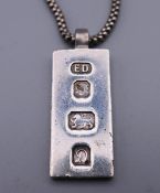 A silver ingot pendant on a silver snake chain. 25.8 grammes.