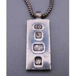 A silver ingot pendant on a silver snake chain. 25.8 grammes.