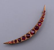 A 9 ct rose gold crescent shaped brooch set with diamonds and almadine garnets with Chester