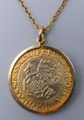 A gilded silver coin housed in an unmarked gold mount and on a 9 ct gold chain. 7.