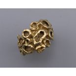 An 18 ct gold ring in an abstract design. Ring size F/G. 10.1 grammes.