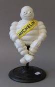 A cast iron Michelin Man on a stool. 26 cm high.