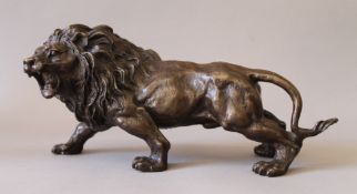 A bronze model of a lion. 33 cm long.