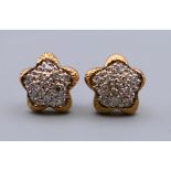 A pair of 9 ct gold diamond star shaped cluster earrings. 1 cm diameter. 1.8 grammes total weight.