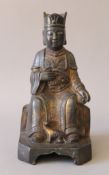 A bronze model of a seated deity. 23 cm high.