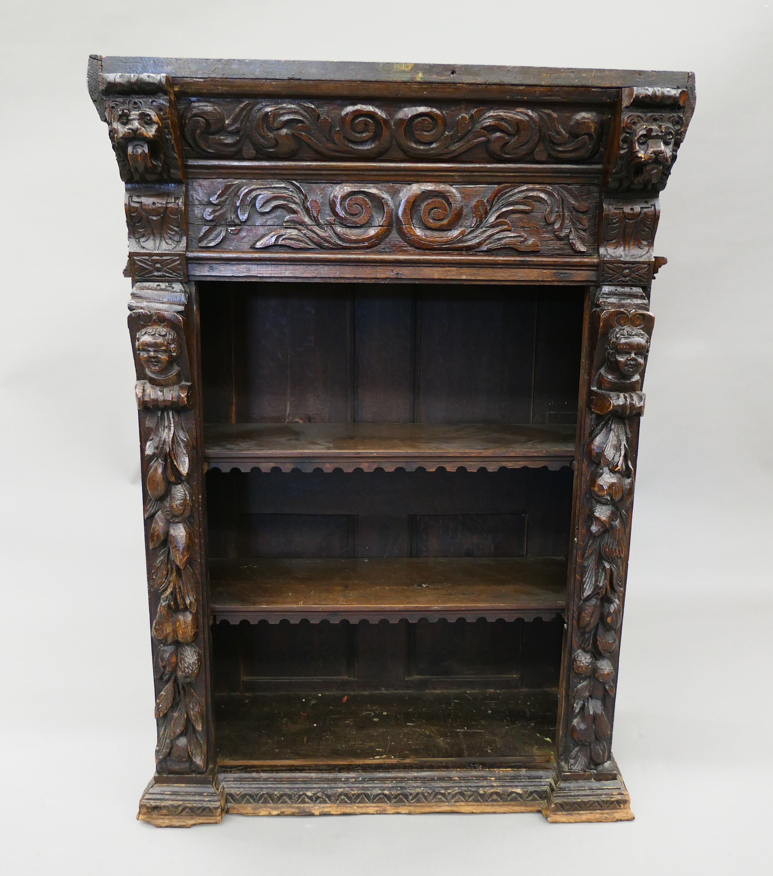 A 19th century oak bookcase carved with figures and foliage. 69.5 cm wide.