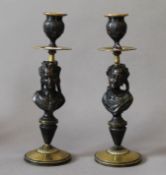 A pair of figural bronze candlesticks. Each 24.5 cm high.