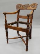 A Ceylonese carved open armchair. 54 cm wide.