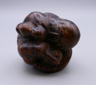 A carved wooden weeping Buddha. 5 cm high.