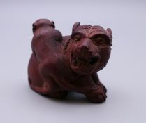 A wooden netsuke formed as a monkey and a lion. 4.5 cm wide.