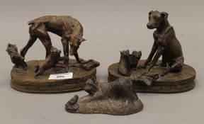 Three resin dog models. The largest 15 cm wide.