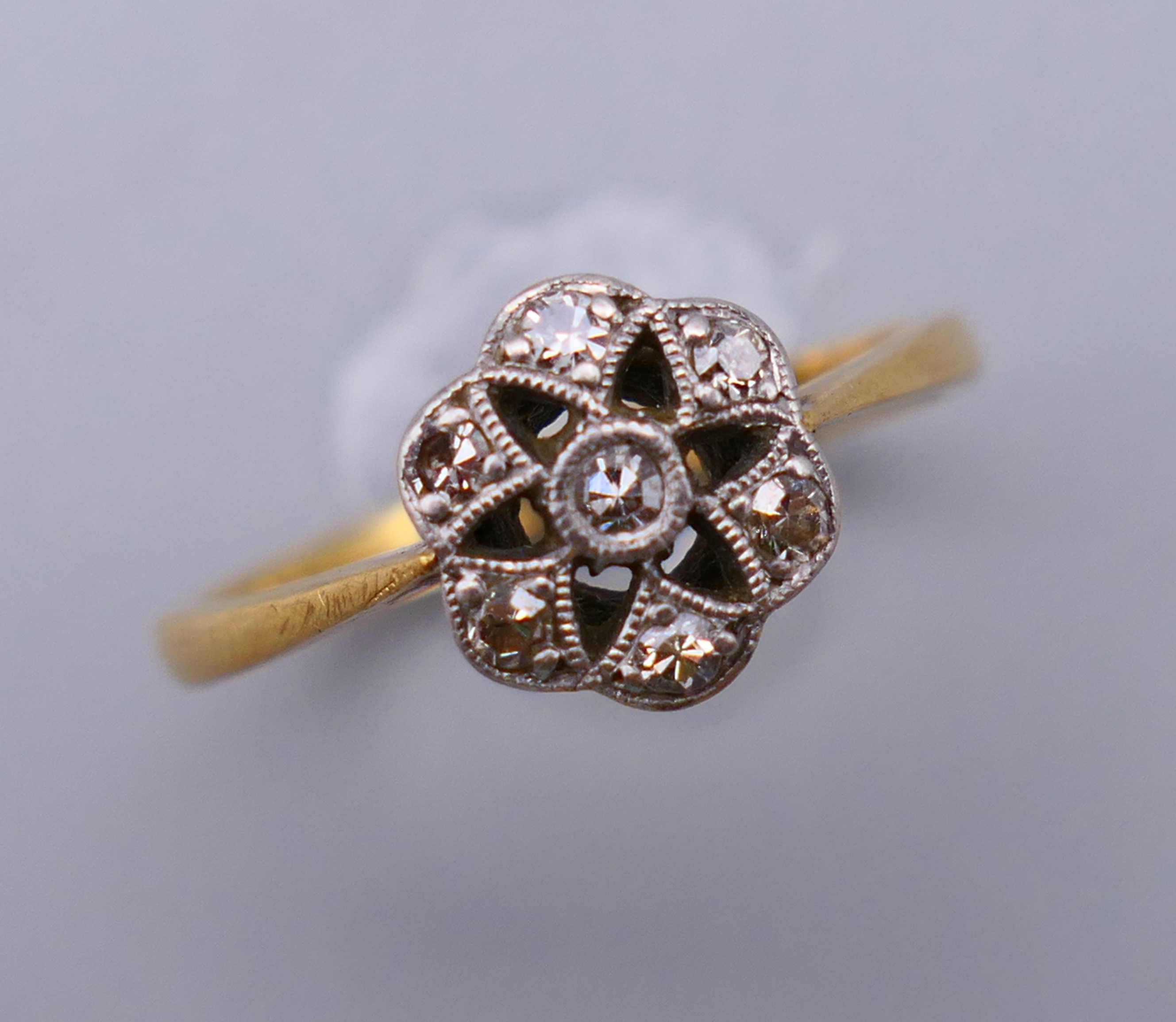 An 18 ct gold and diamond flower head ring. Ring size M. 8 mm high. - Image 2 of 8