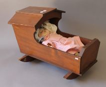 A vintage doll in a wooden cradle. The cradle 47 cm long.