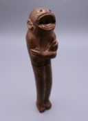 A Japanese carved wood and bone paperknife formed as a monkey. 17 cm long.