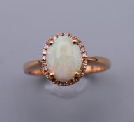 A 14 ct gold, opal and diamond ring. Ring size O.