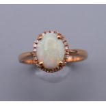 A 14 ct gold, opal and diamond ring. Ring size O.