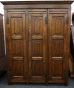 An oak linen fold triple wardrobe. 154 cm wide x 192 cm high x 59 cm deep.