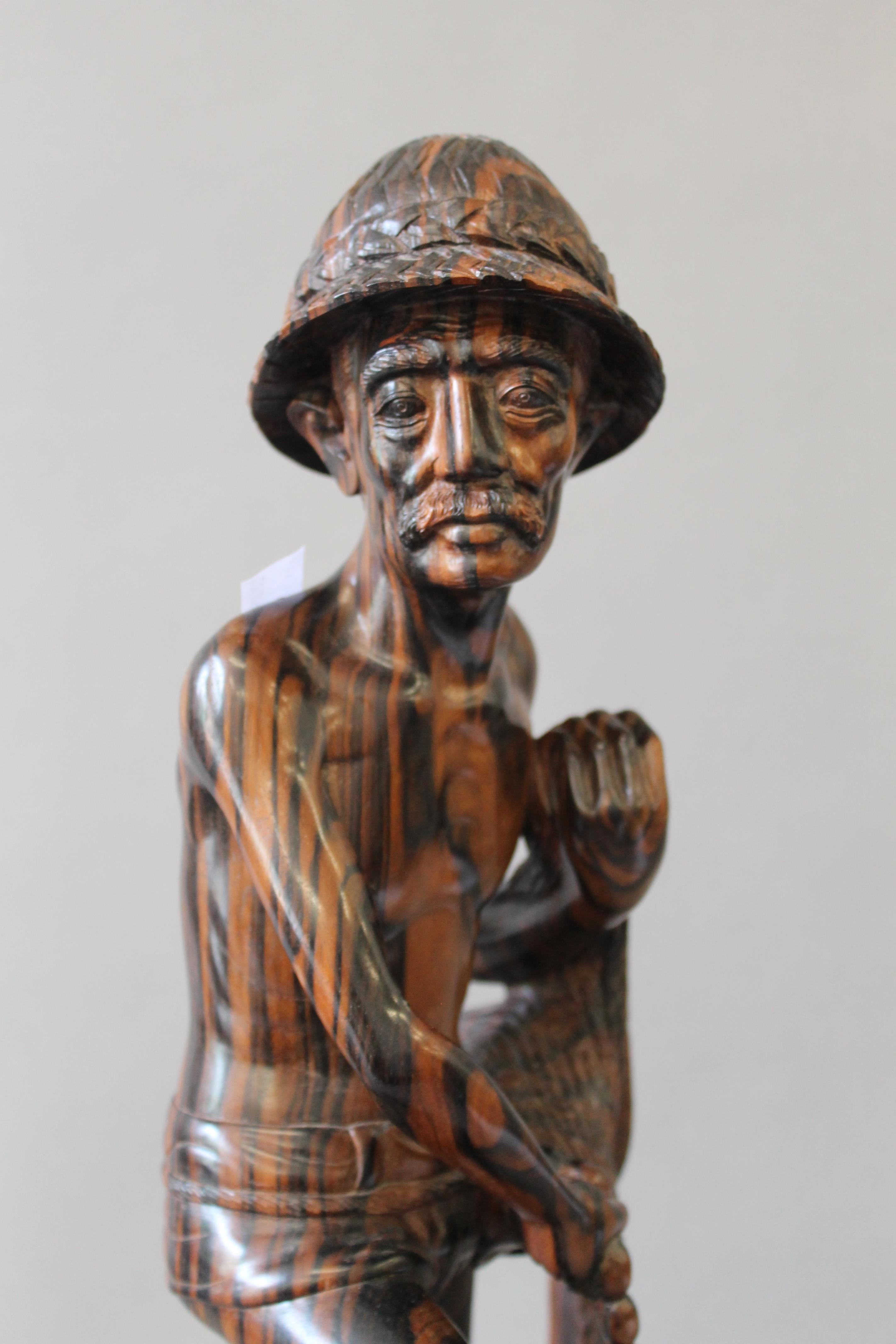 An Eastern carved hardwood fisherman figure. 43 cm high. - Bild 4 aus 5