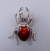 A silver enamel beetle brooch. 4.5 cm long.