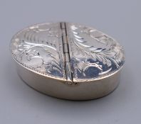A silver engraved double sided pill box. 4 cm wide.