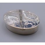 A silver engraved double sided pill box. 4 cm wide.