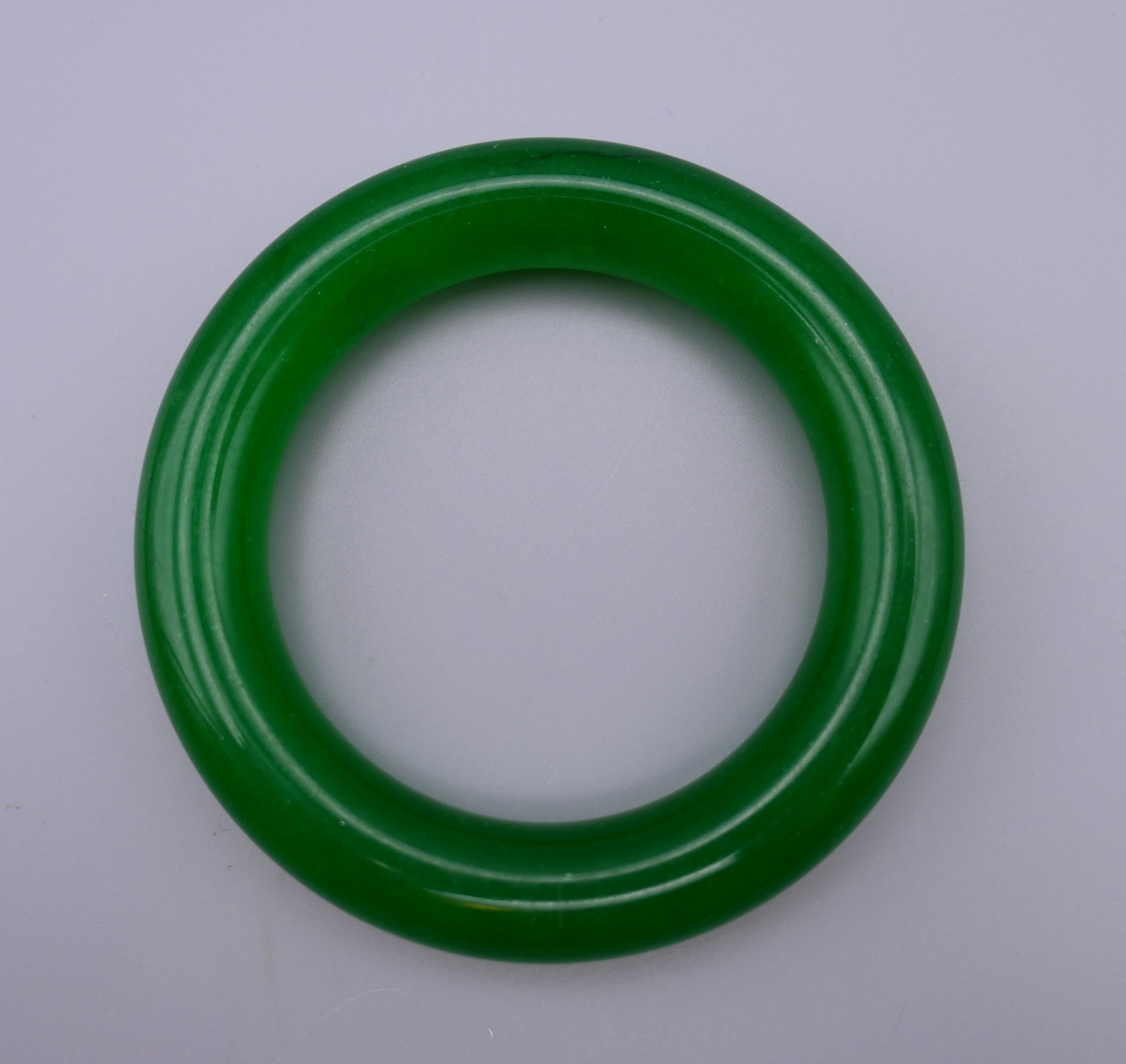 An apple green jade bangle. 8.5 cm diameter.