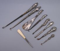 A quantity of silver handled button hooks, etc.