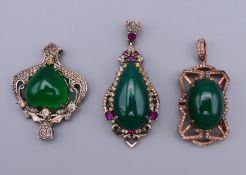 Thee silver and jade pendants. The largest 4.5 cm high.