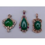 Thee silver and jade pendants. The largest 4.5 cm high.