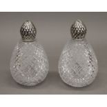 A pair of silver topped and cut-glass scent bottles. 14.5 cm high.