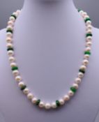 A string pearl and jade bead necklace with a 14 ct gold clasp. 42 cm long.