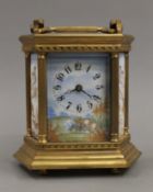 A brass cased carriage clock set with enamel panels. 17 cm high.