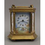 A brass cased carriage clock set with enamel panels. 17 cm high.