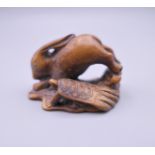 A Japanese hare and tortoise wooden netsuke. 4 cm long.